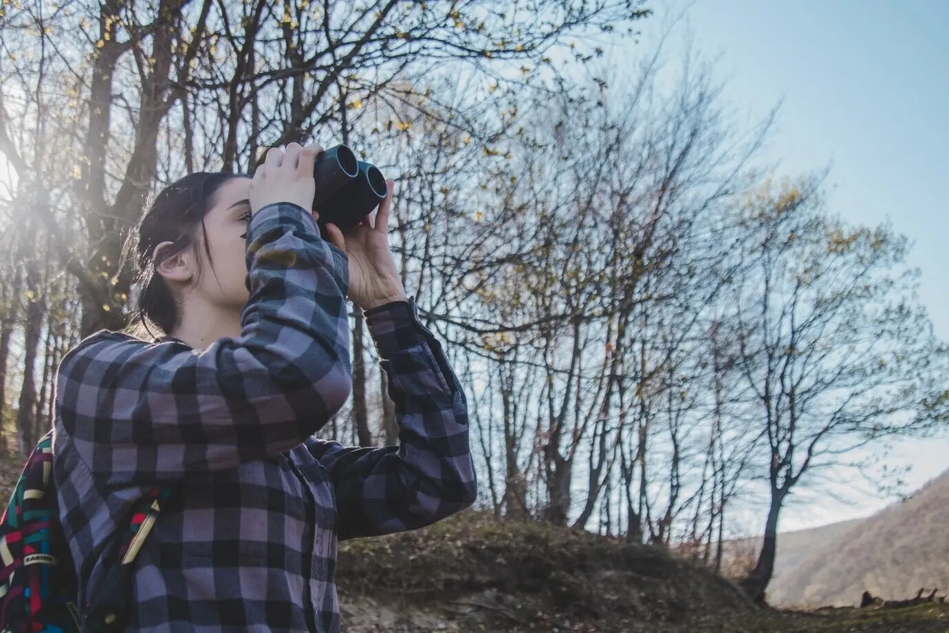 Unteransicht einer jungen Frau mit Fernglas